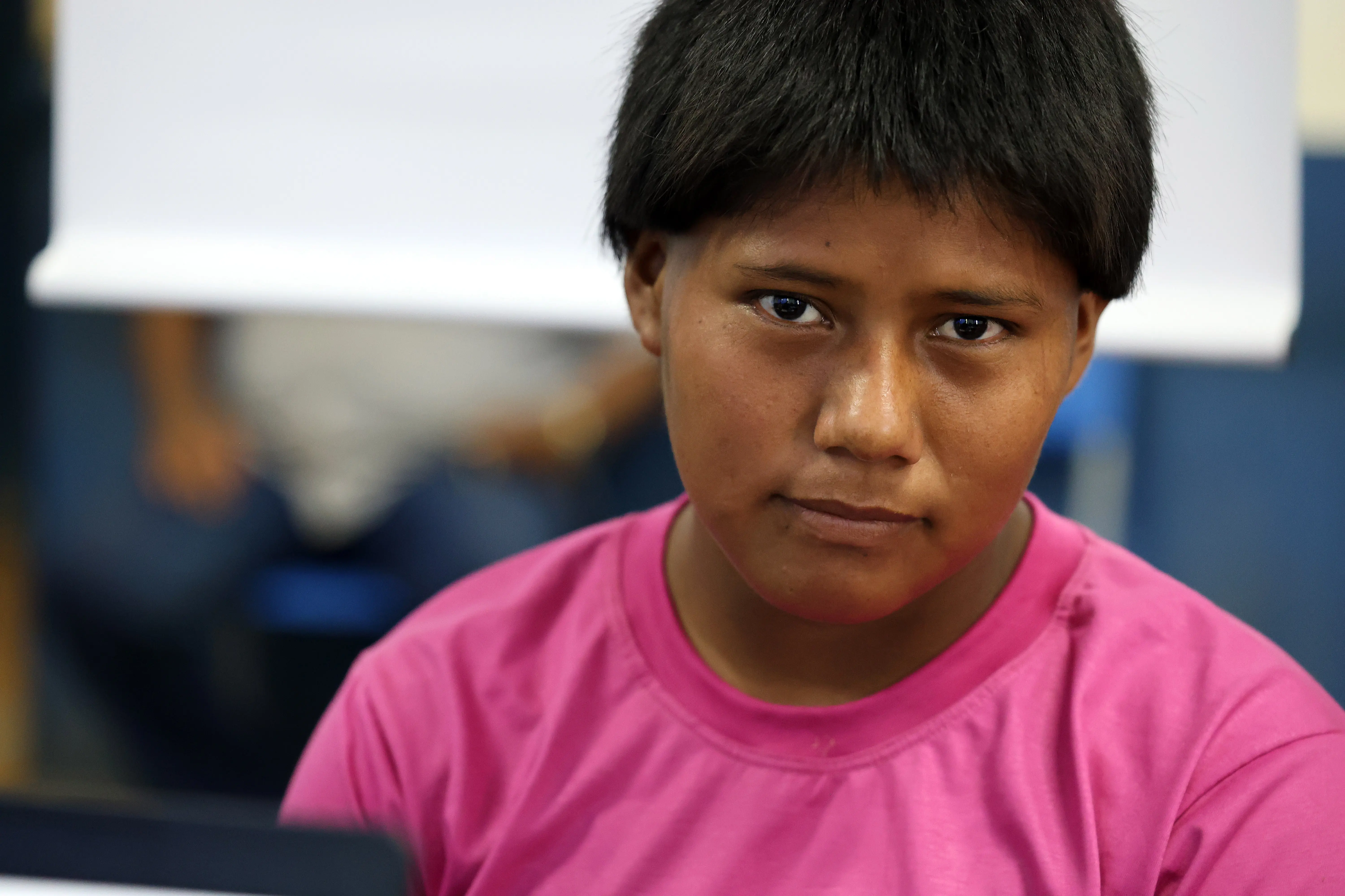 Retrato em close de jovem indígena Xavante, de camiseta rosa, olhando para a câmera com expressão serena. A foto evidencia o momento de conquista da cidadania durante a Expedição Araguaia-Xingu.