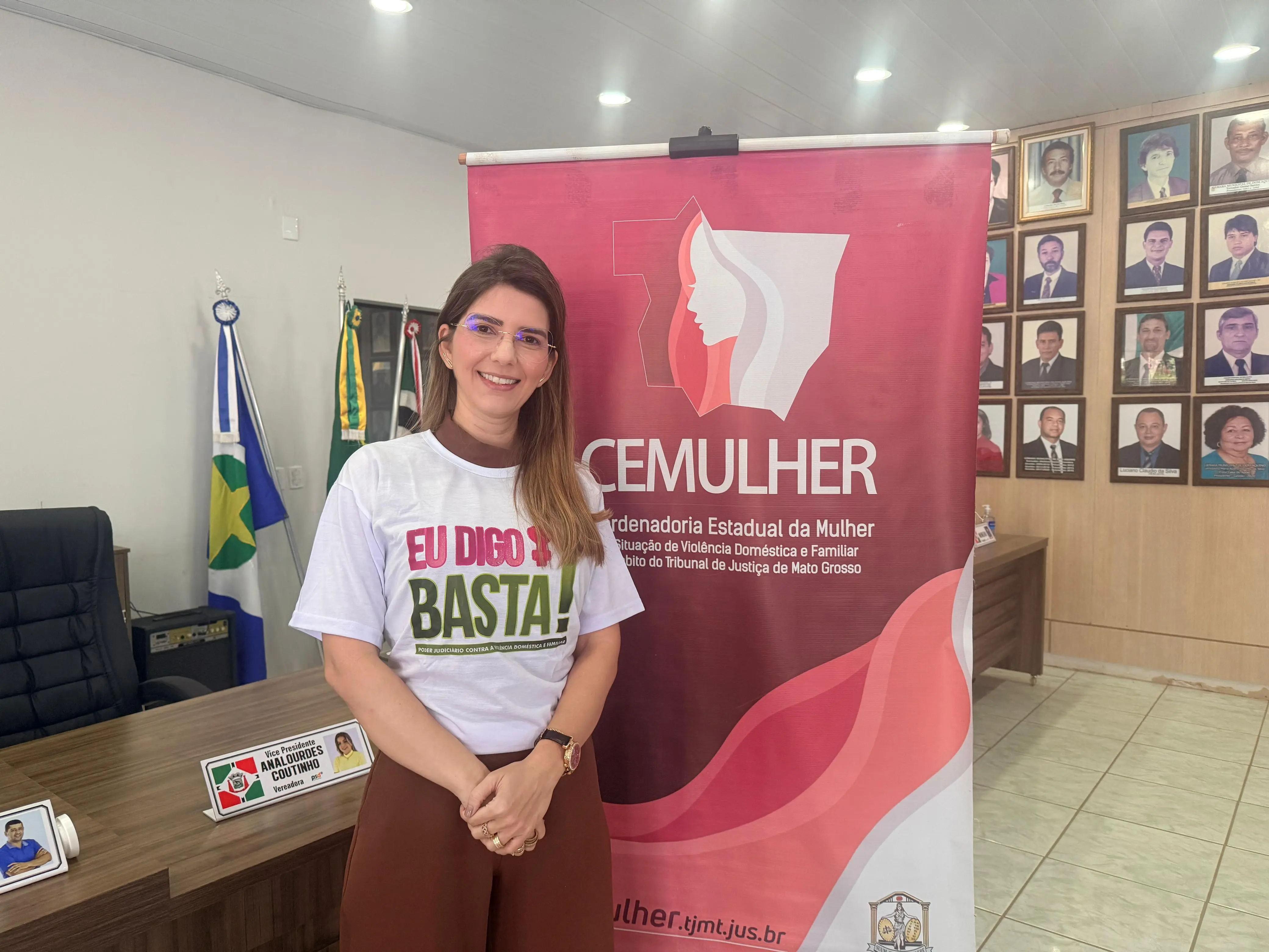 Uma mulher de cabelos castanhos, veste camiseta branca com a frase 