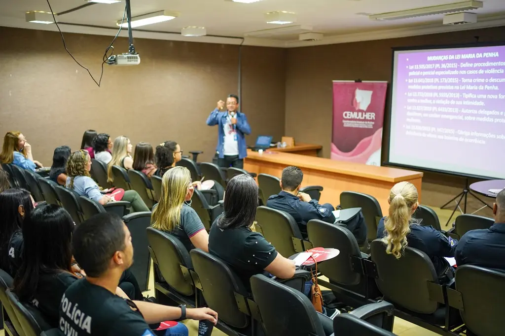 em um auditório, servidor da Cemulher profere palestra a membros da rede de enfrentamento à violência contra a mulher.