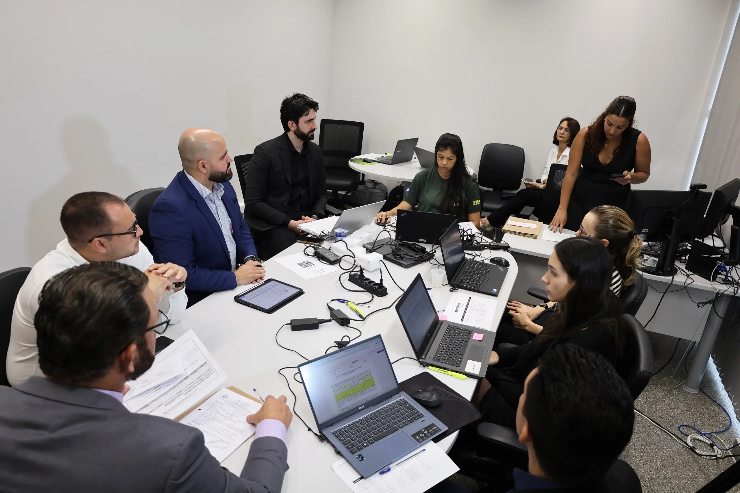 Audiência de conciliação em que advogados do infrator e representantes das instituições participantes do mutirão estão sentados em uma mesa