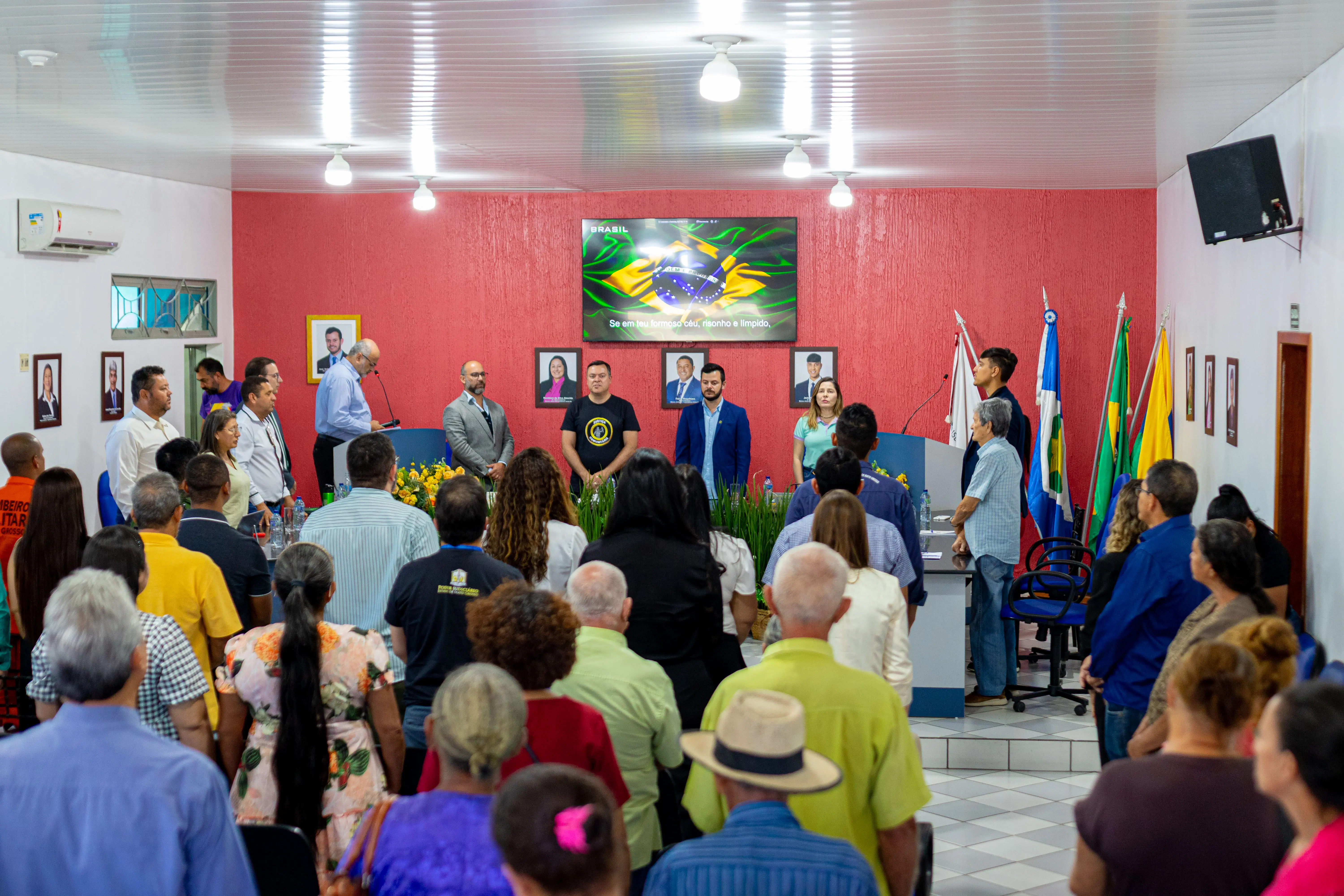 Foto em plano aberto que mostra o plenário da Câmara de Nova Brasilândia lotada de pessoas que participam de uma audiência pública. 
