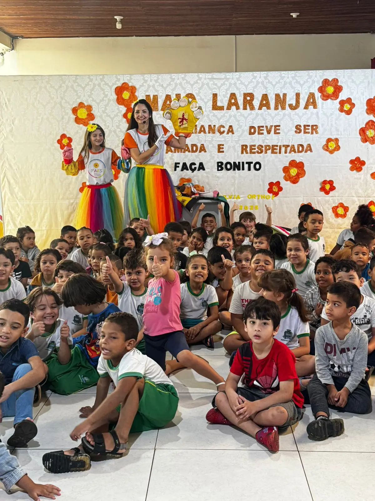 grupo de pessoas perfiladas lado a lado em via pública. Participantes da caminhada seguram faixas e cartazes, em ação de mobilização contra a violência sexual infantil