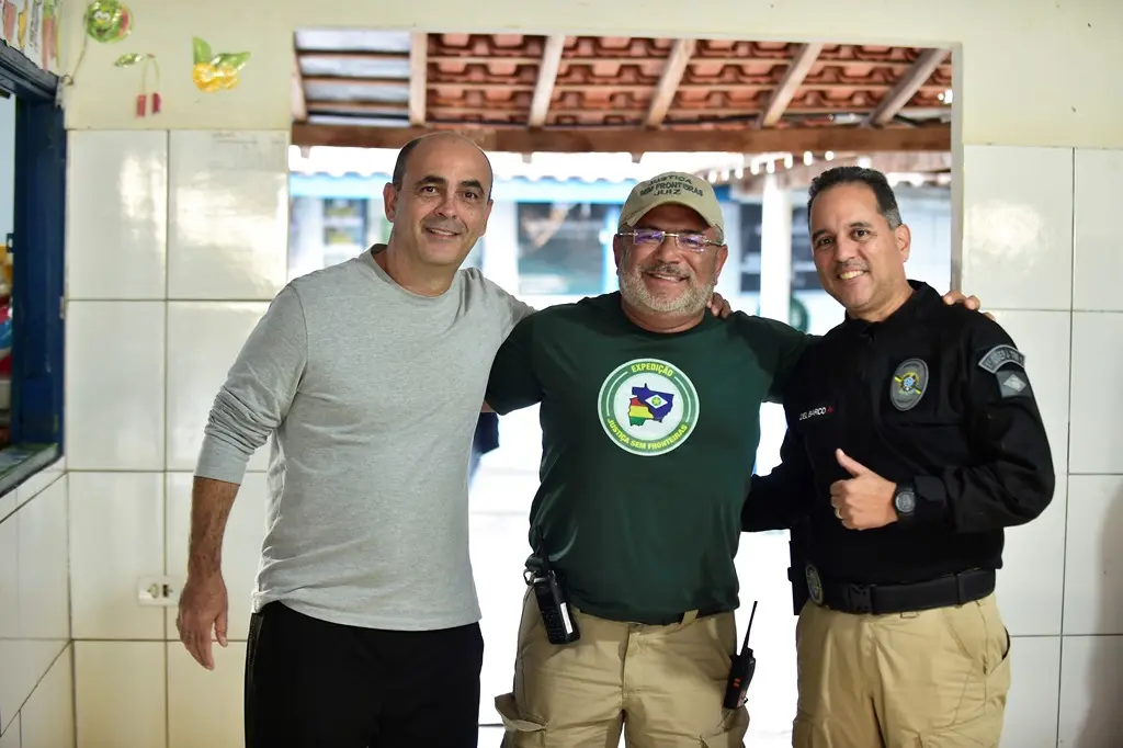 Foto que mostra o juiz José Antônio Bezerra Filho abraçado aos dois servidores da Justiça Federal, no pátio de uma escola onde ocorreu o mutirão da Justiça Sem Fronteiras.