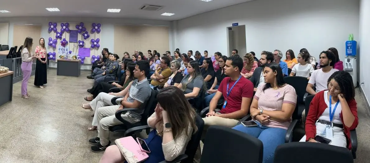 Foto que mostra a juíza Djéssica Küntzer e a promotora de justiça Clarisse Moraes proferindo palestra a dezenas de servidores, no Plenário do Tribunal do Júri.