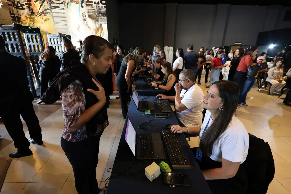 Foto horizontal em plano aberto que mostra a equipe de credenciamento do TJMT Inclusivo atendendo ao público, no interior da Igreja Lagoinha.
