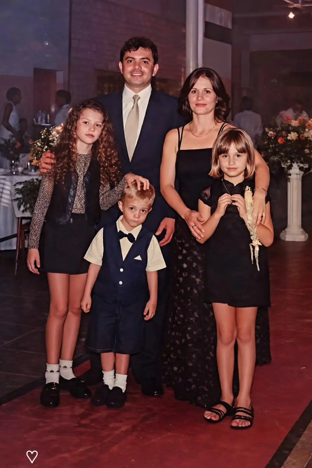Foto vertical antiga que mostra o agente da Infância e Juventude, Aparecido Donizete, com a ex-mulher, duas filhas e o filho ainda crianças, em uma festa. Eles posam sorrindo para a foto.