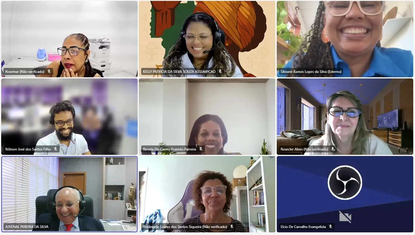 Print de tela de uma videoconferência que mostra os participantes do curso de letramento racial e antirracismo sorrindo.