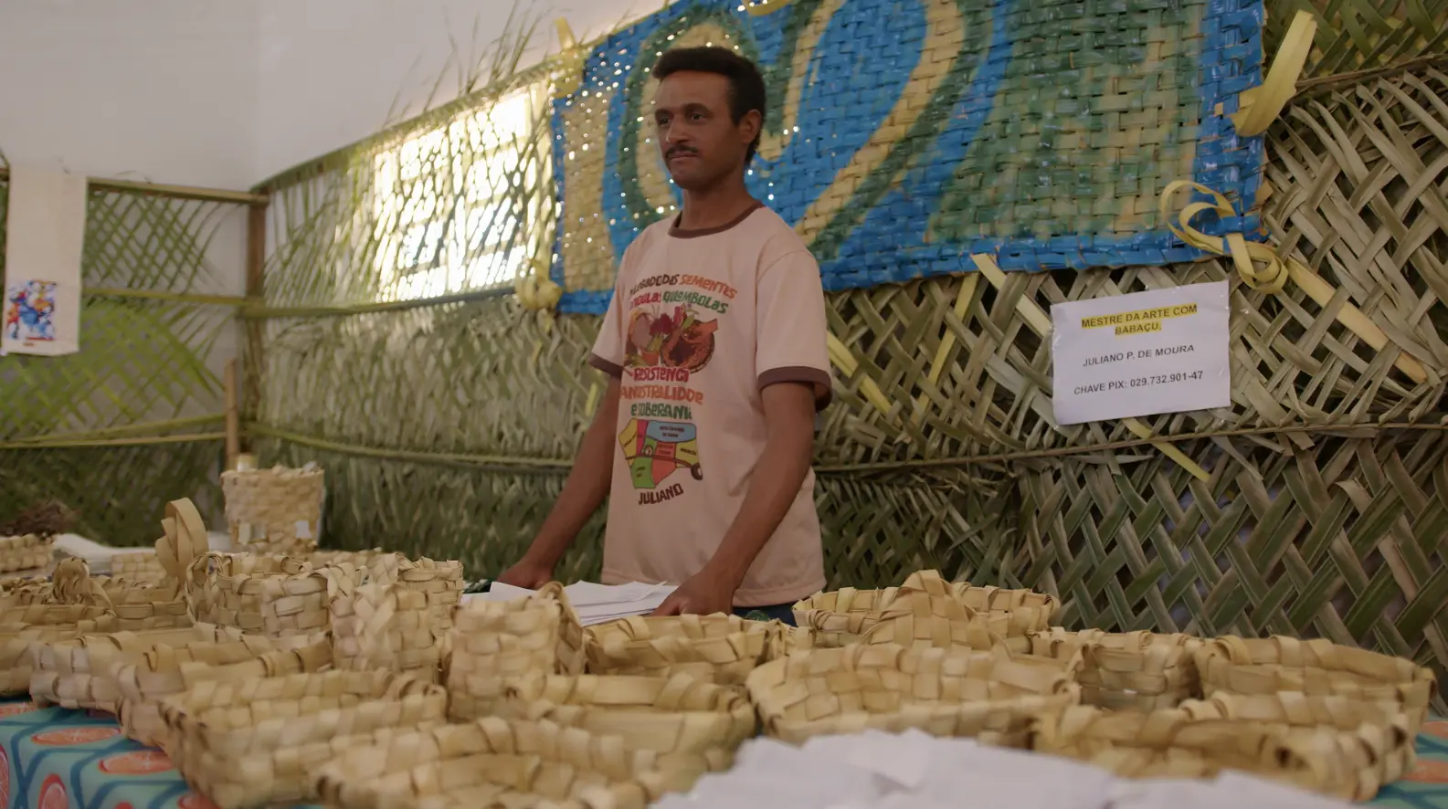 foto que mostra um artes�o expondo cestos de palha