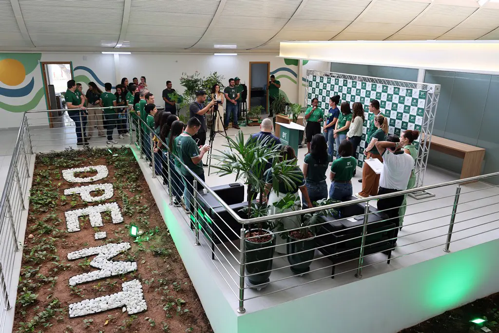 Foto horizontal colorida, em plano aberto, que mostra o saguão da sede da Defensoria Pública de Mato Grosso cheio de pessoas, a maioria com a camiseta verde da instituição, participando de evento em parceria com o programa Verde Novo.