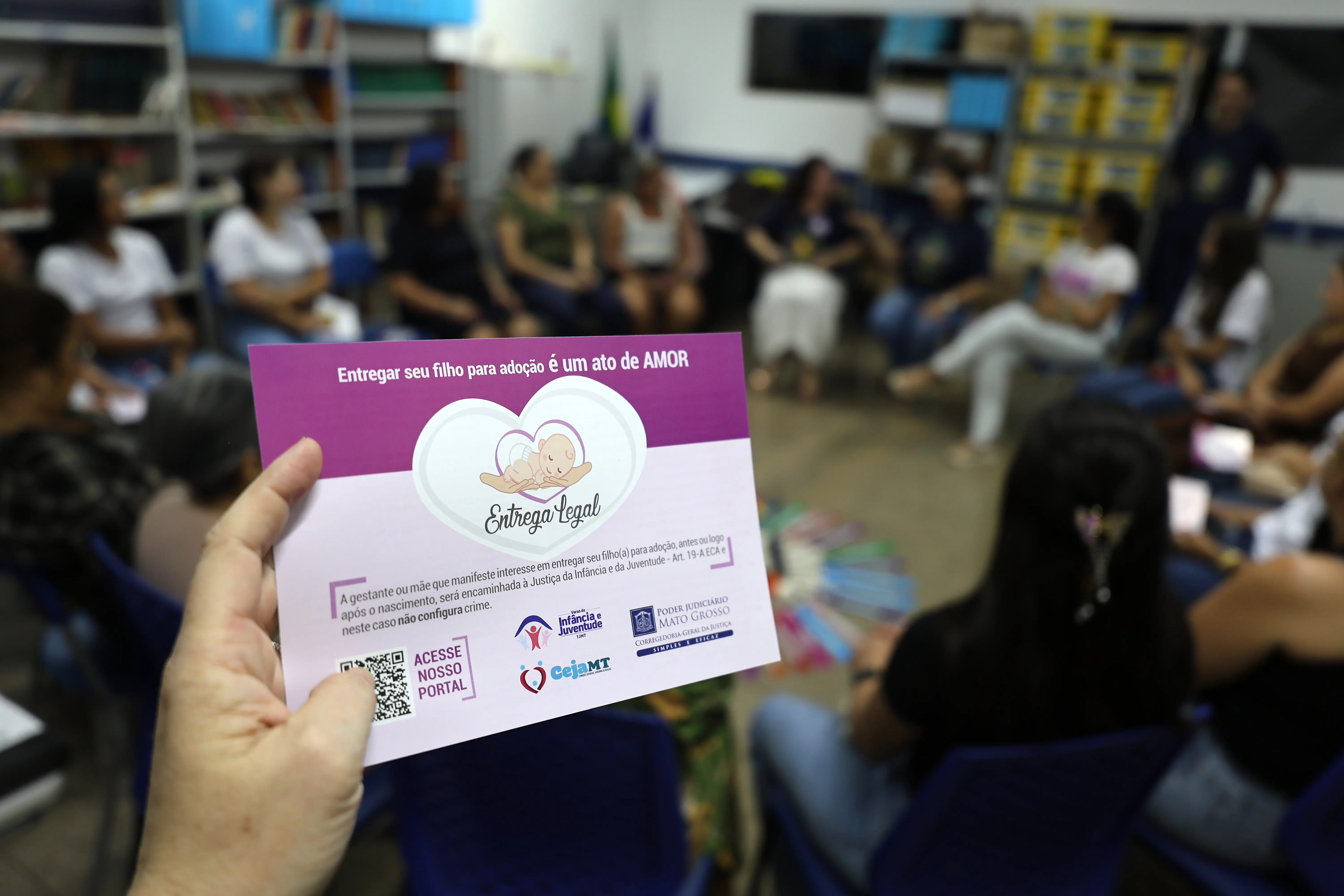 Folheto sobre entrega legal; reforça a mensagem de amor na adoção. Design institucional, usado em ações de conscientização.