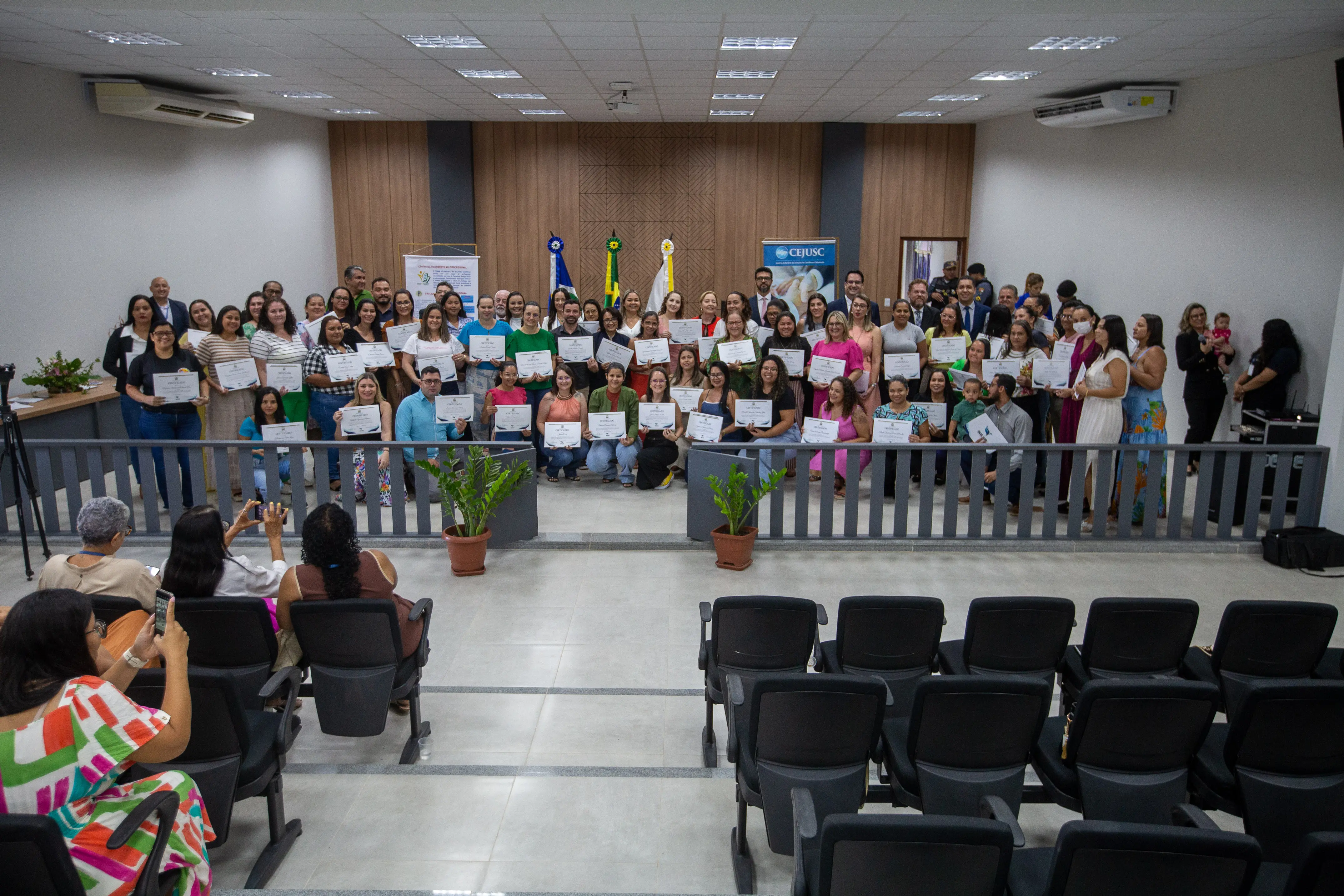 foto colorida na horizontal, com a presidente junto dos facilitadores que receberam os certificados e todas as autoridades que compuseram a mesa