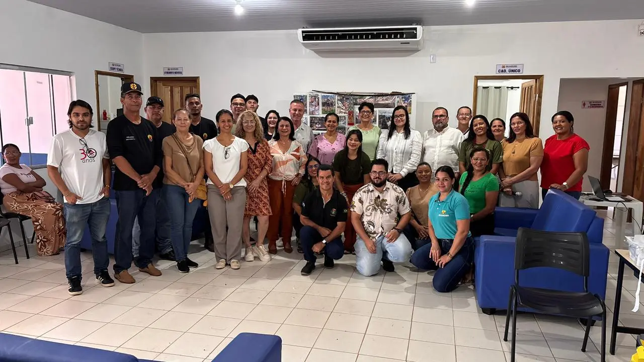 Parceiros envolvidos na realização do Registre-se posam para foto, em pé e abaixados, em um ambiente interno de atendimento.