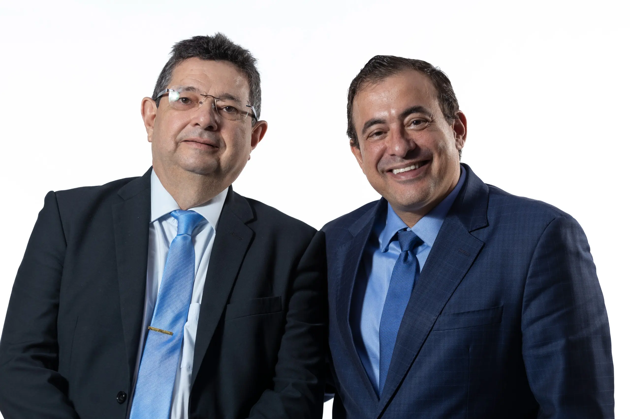 Foto do corregedor e do juiz auxiliar da CGJ. Os dois homens usam terno e gravata posam lado a lado, em fundo claro, para foto institucional. Ambos estão em posição frontal, com expressão serena