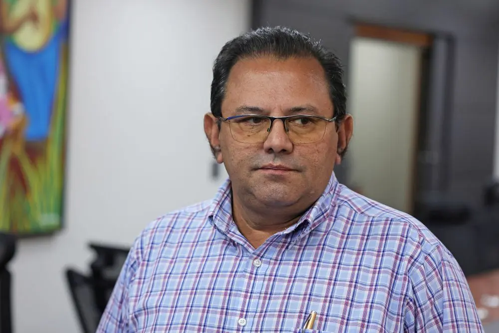 Foto horizontal que mostra o presidente do Sindicato Rural de Santo Antônio de Leverger, Antônio Carlos Carvalho, do busto pra cima. Ele é um homem negro, de cabelo liso e preto, usando óculos de grau e camisa azul xadrez.