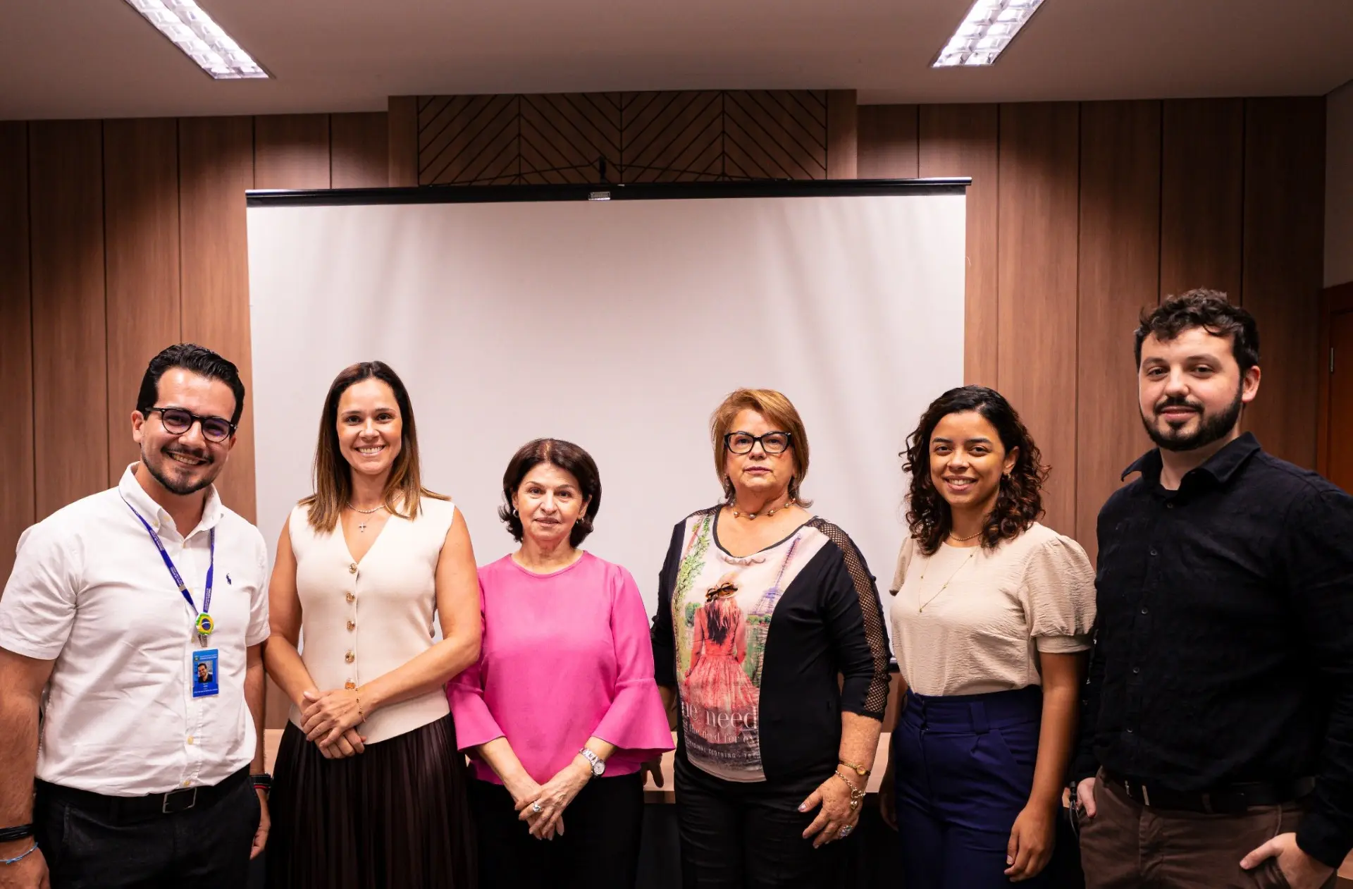 Foto horizontal que mostra a equipe responsável pela apresentação do Programa de Acolhimento e Formação Inicial dos Estagiários dos Juizados Especiais. São quatros mulheres e dois homens, que posam sorrindo para a foto.