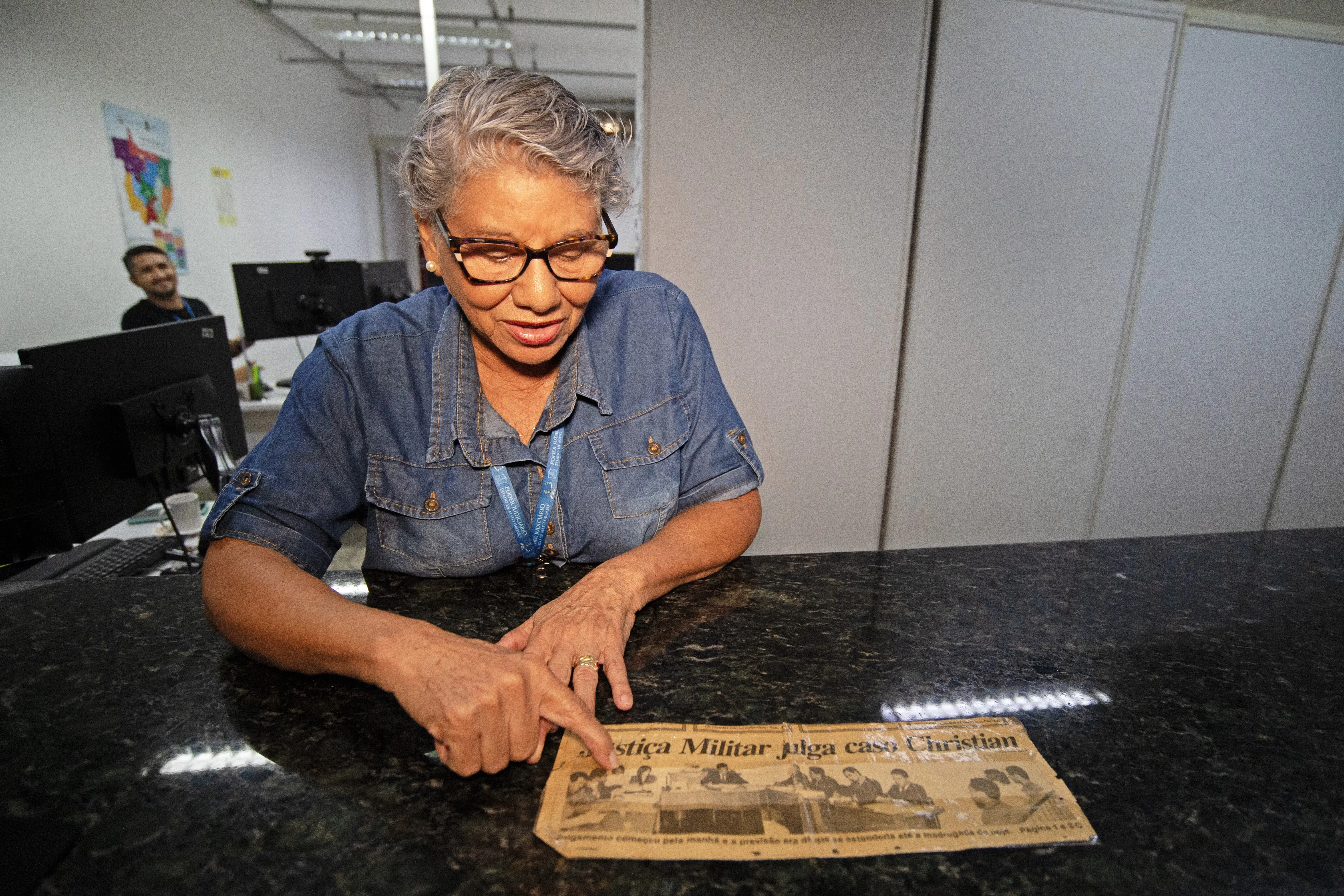 Serv idora do Fórum de Cuiabá observa documento antigo