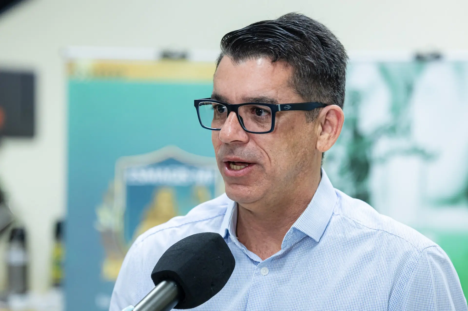 Foto horizontal do juiz Michel Lofti, durante entrevista à TV. Ele é um homem branco, de cabelo grisalho, vestindo camisa azul-clara de botões e usando óculos de grau de armação preta. 