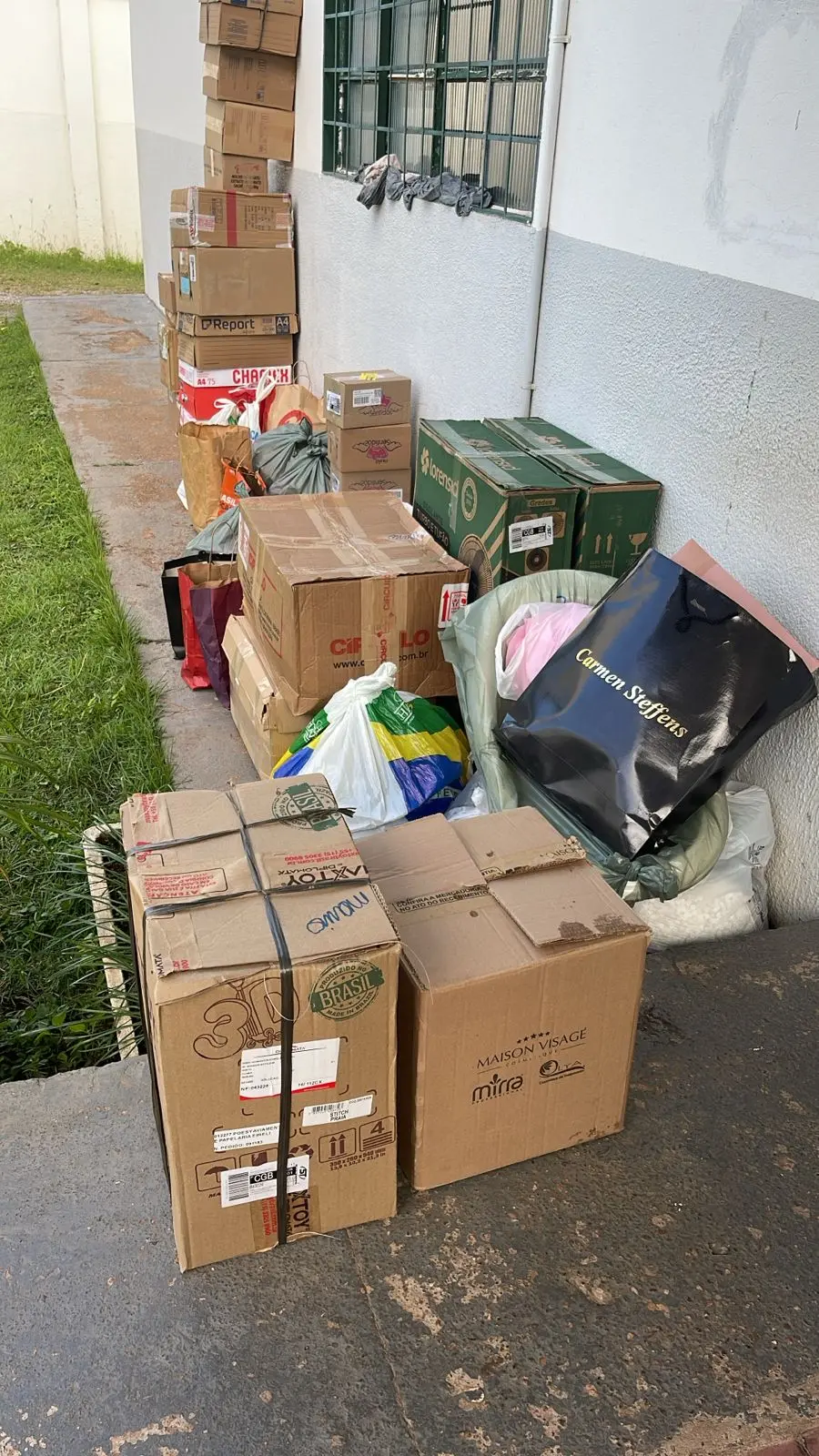 Foto em ângulo fechado de várias caixas entregues na Casa de Amparo, resultado de campanha realizada no TJ e por parceiros