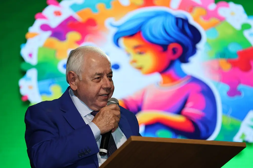 Desembargador José Zuquim Nogueira falando na tribuna do evento TJMT Inclusivo. ele é um senhor branco, de cabelos brancos, usando terno azul.