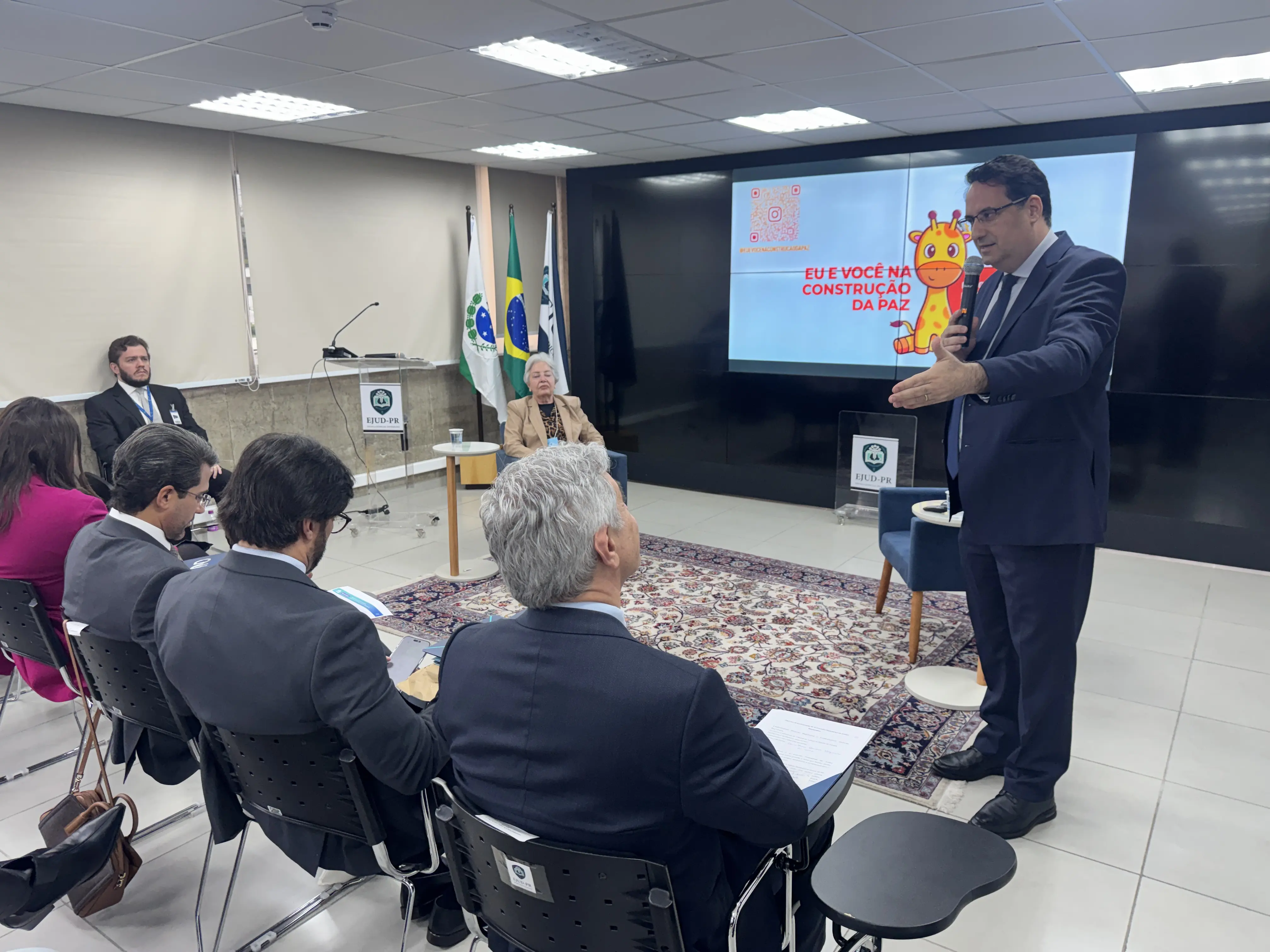 Em imagem focada o juiz Túlio Duailibi se dirige aos demais magistrados que ocupam a primeira fila do evento.