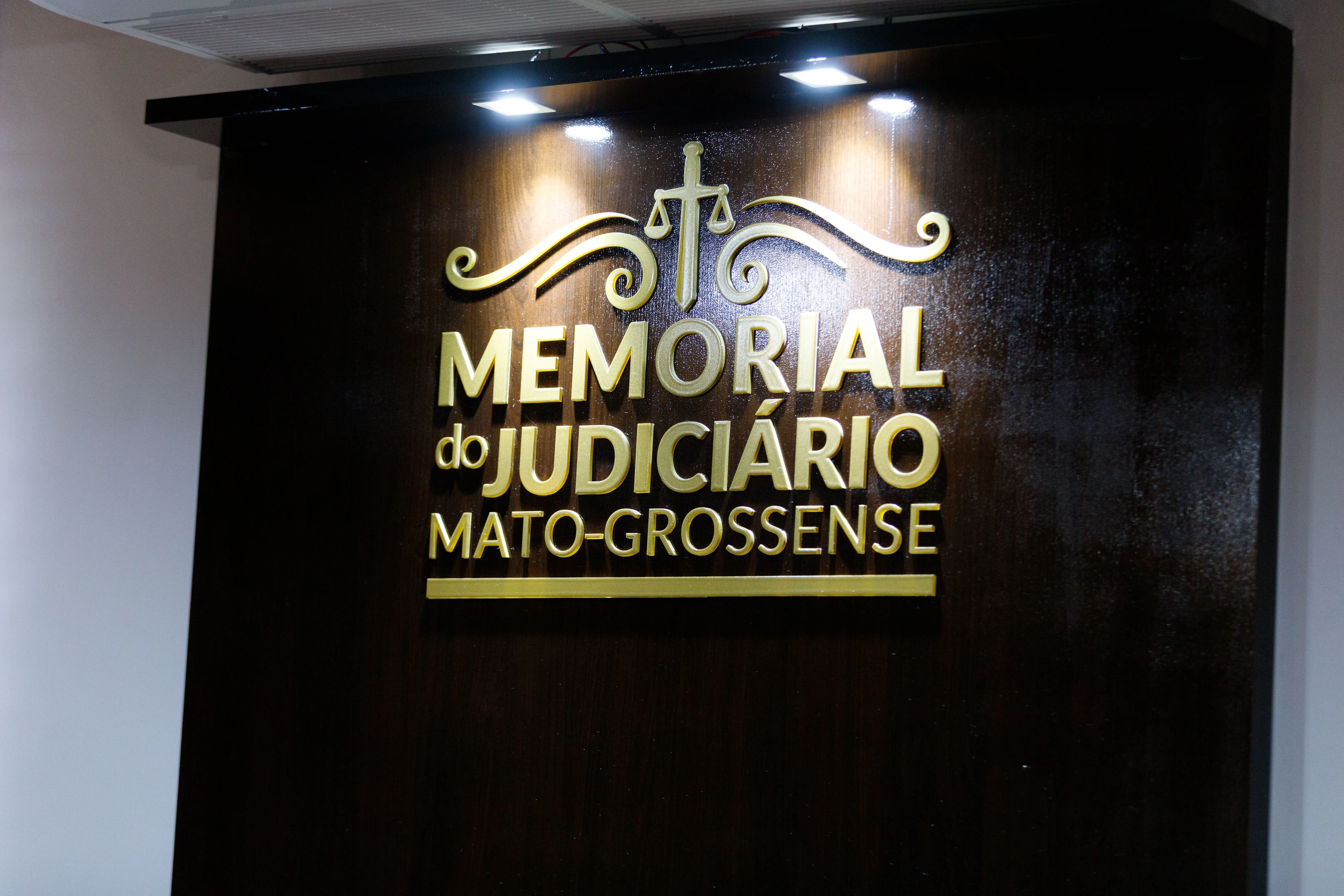 Placa onde está escrito com  letras douradas: Memorial do Judiciário Mato-grossense
