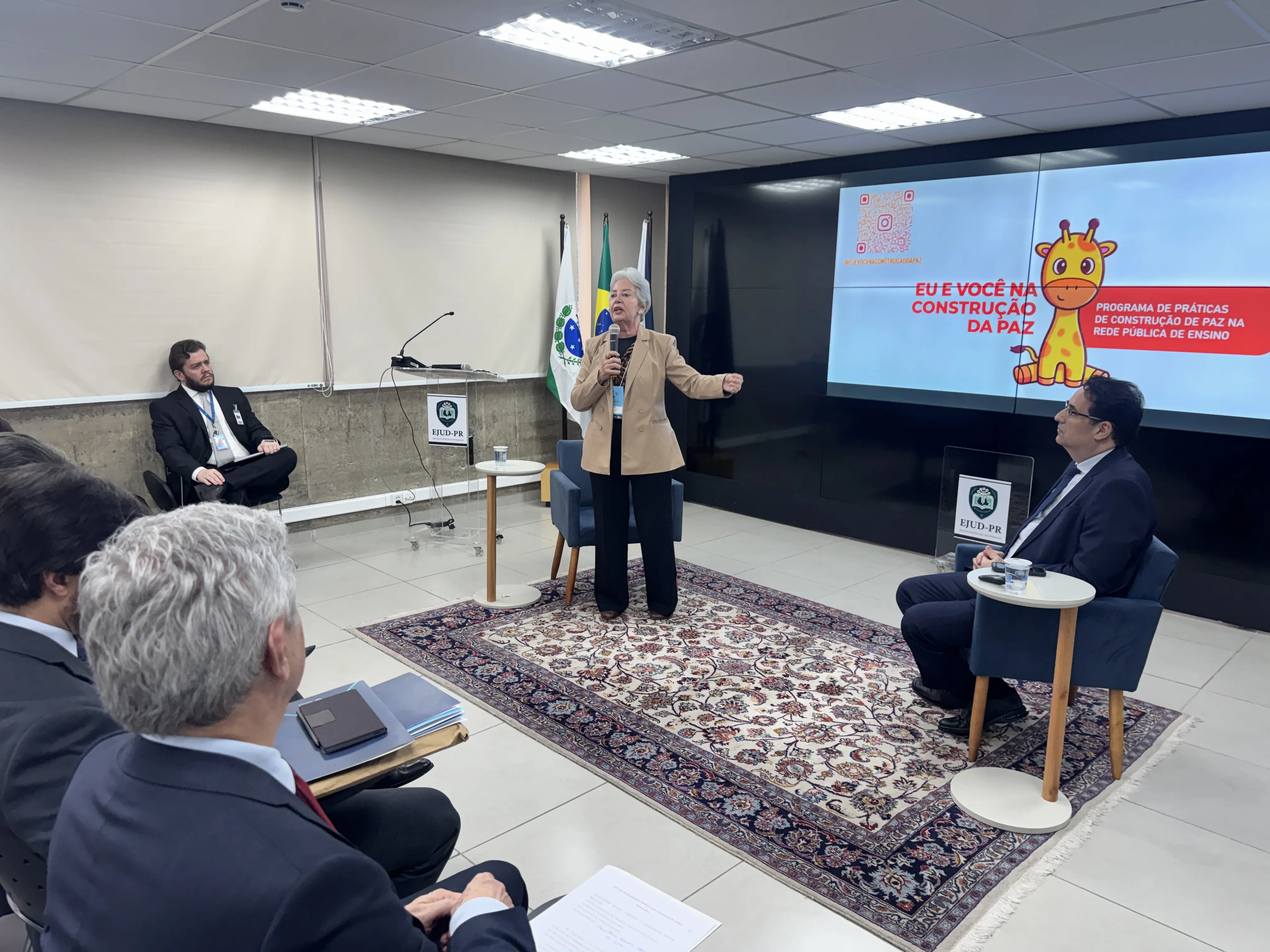 A desembargadora e presidente do Núcleo Gestor da Justiça Restaurativa Clarice Claudino da Silva faz uso da palavra no mesmo auditório.