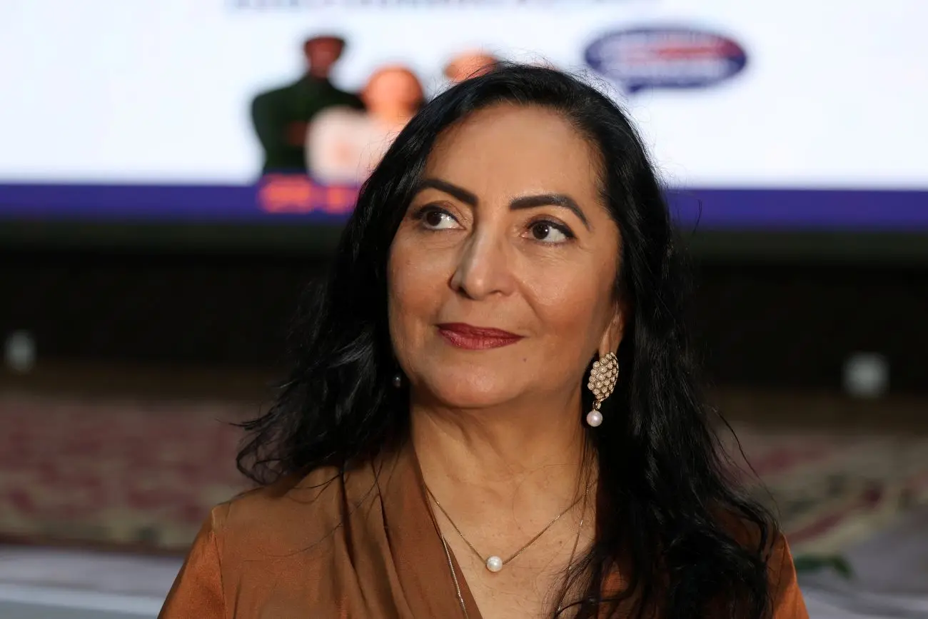 Foto horizontal colorida que mostra a coordenadora de Gestão de Pessoas do TJMT, Claudenice Deijany, do busto pra cima. Ela é uma mulher de pele parda, olhos e cabelos pretos, usando blusa cor de bronze e conjunto de colar e brincos de pérola. 