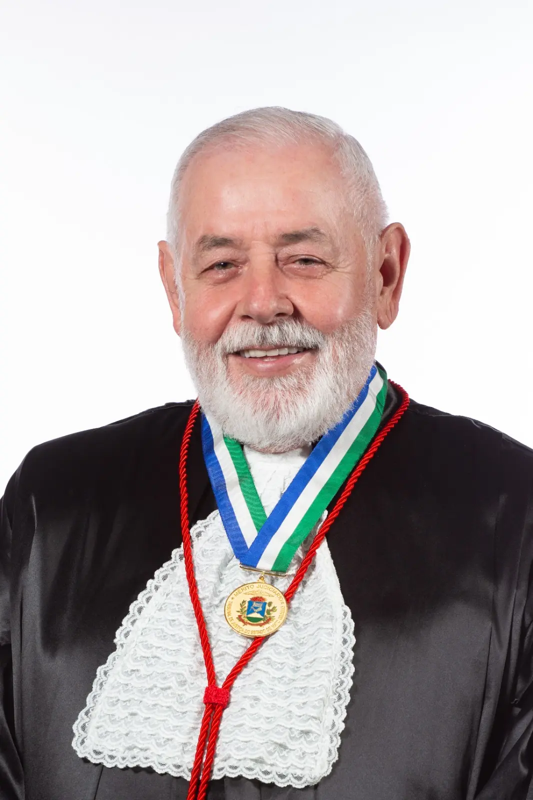 Retrato institucional do desembargador José Zuquim Nogueira usando medalha oficial. A imagem destaca o traje formal e fundo neutro, voltada à divulgação institucional.