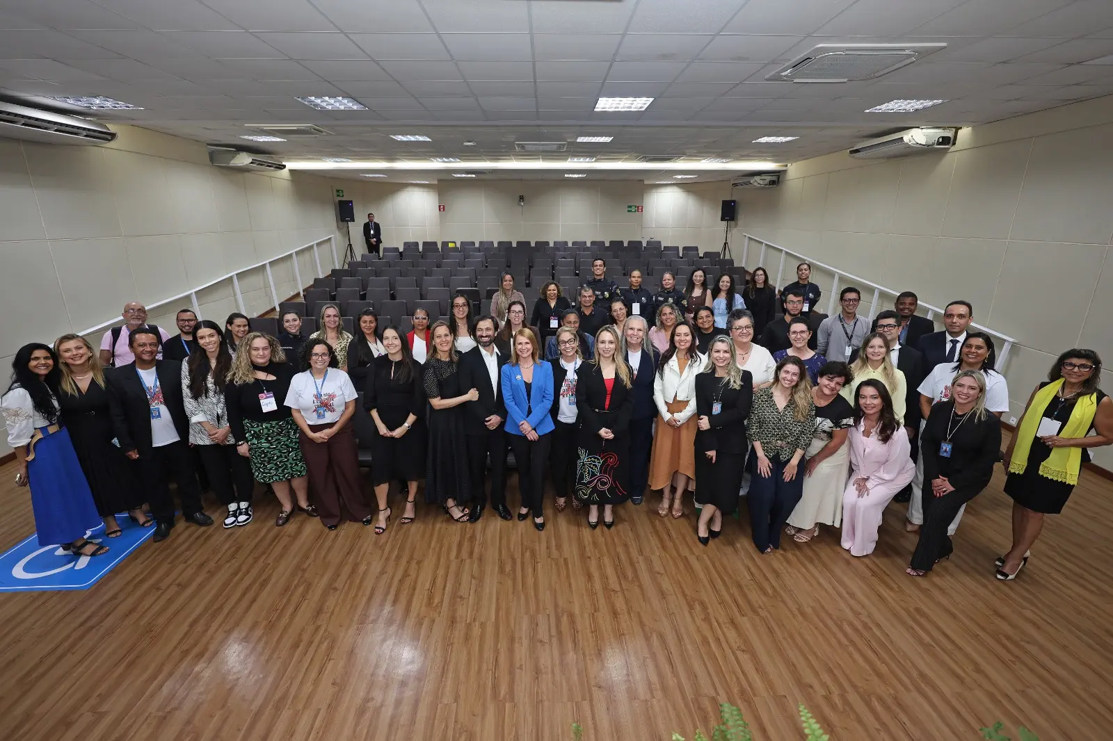 Registro coletivo dos integrantes das redes de enfrentamento à violência doméstica e familiar, reunidos no Auditório Gervásio Leite, no TJMT. O grupo posa para foto oficial em frente às cadeiras do auditório, reunindo representantes do Judiciário, instituições parceiras e órgãos da rede, em clima de