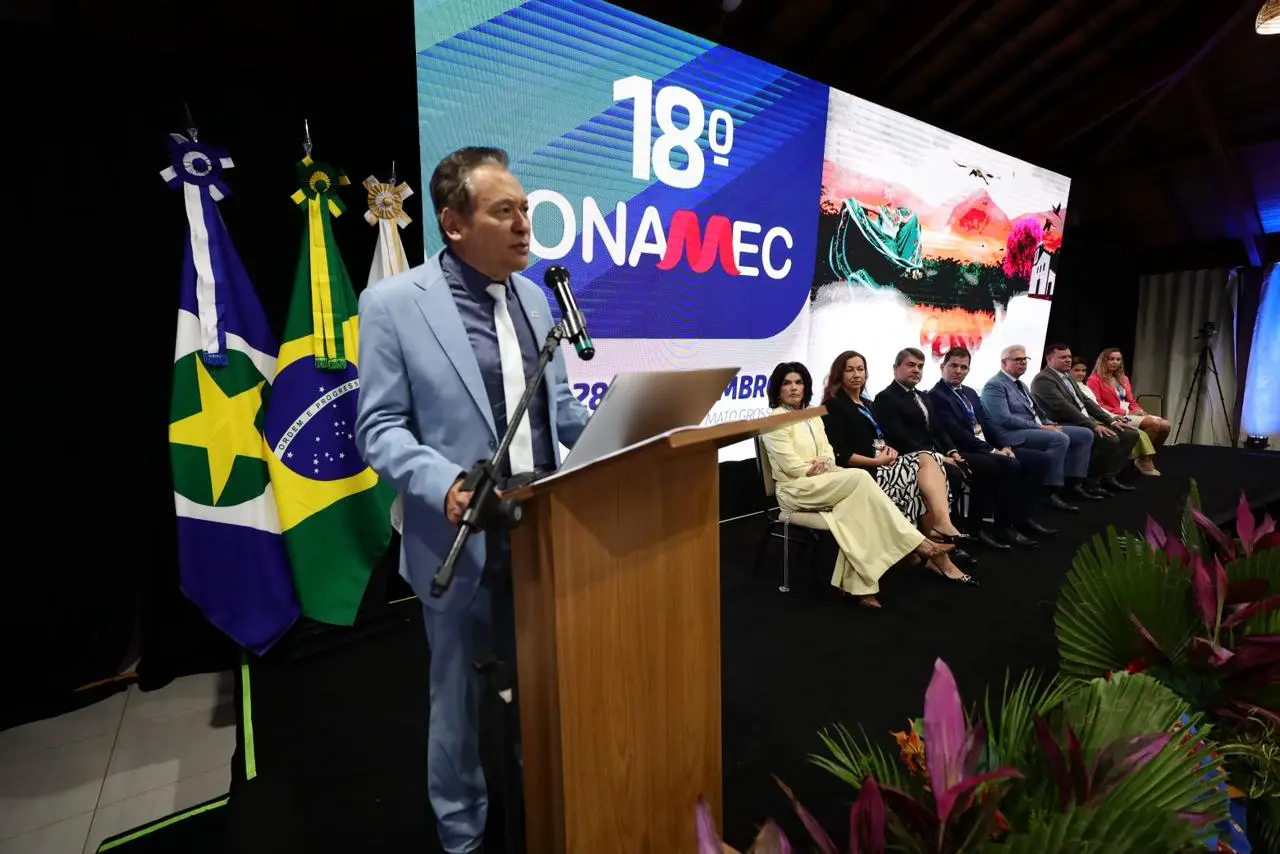 Foto do dispositivo de honra composto por autoridades. No púlpito, falando ao microfone, está o desembargador Mário Kono.