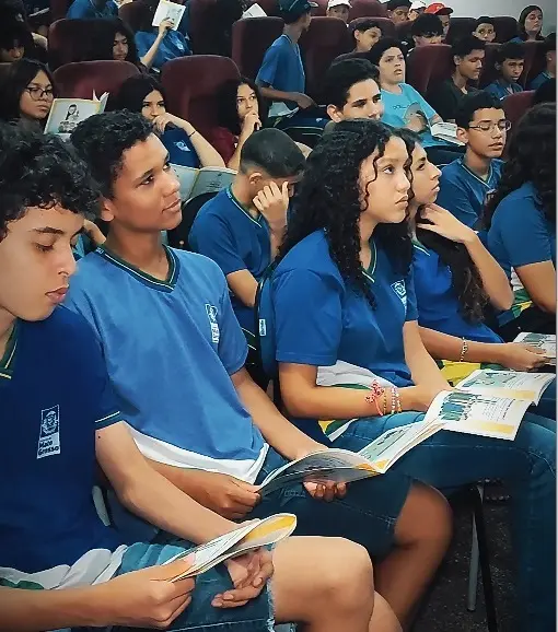 Jovens usando uniforme azul assistindo palestra do Nosso Judiciário