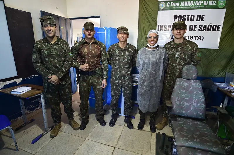 Foto que mostra os militares do Exército que atuam na área da Saúde. Eles estão em pé, lado a lado. Da esquerda para a direita: aspirante Matheus Moreira (médico), cabo Danilo Ramos, soldado Máximus, tenente Taíz Moraes (cirurgiã dentista) e soldado Vitorazzi.
