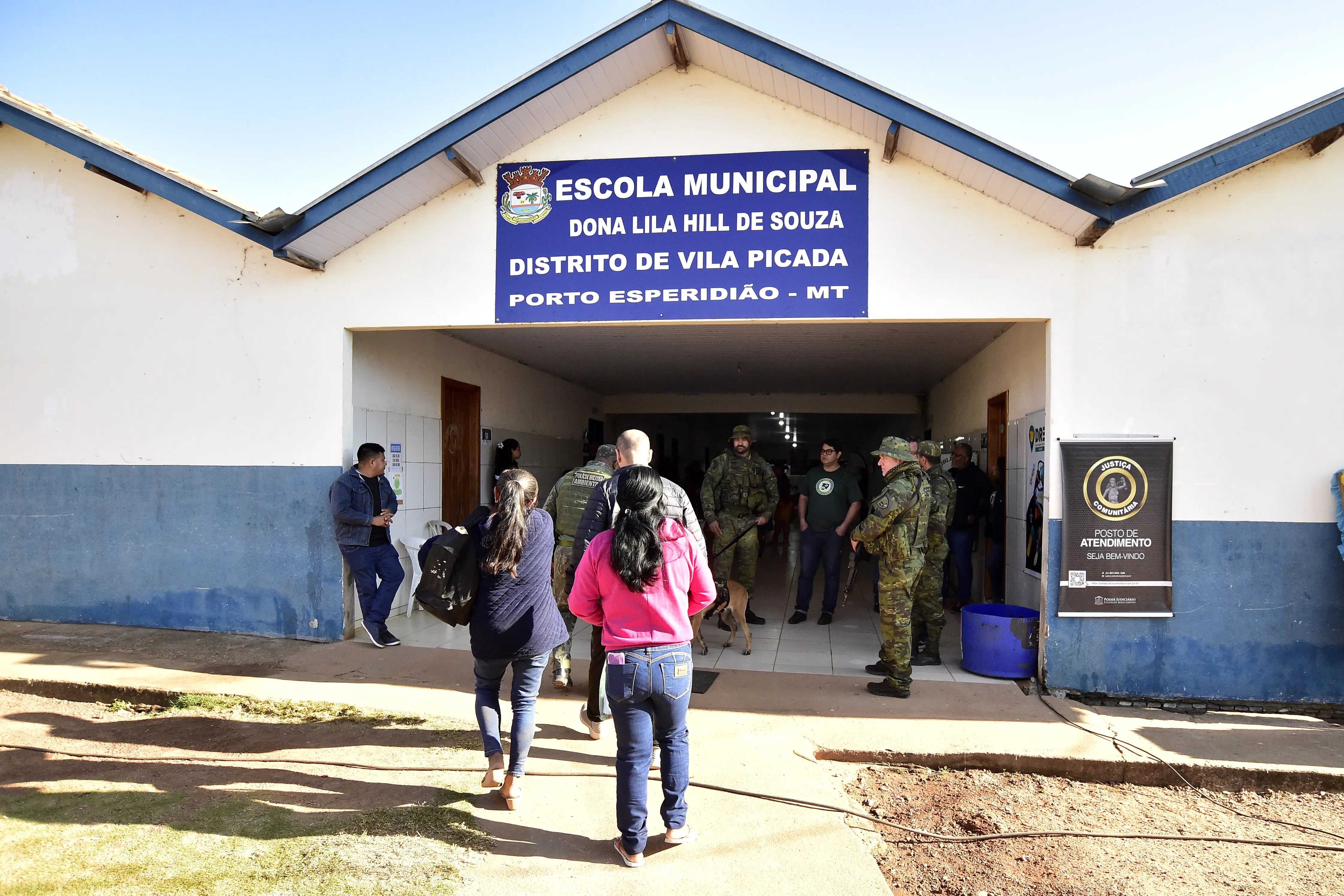 Foto da fachada da Escola Municipal Dona Lila Hill de Souza com movimentação de pessoas em frente.