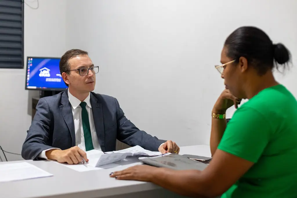 Defensor público Rubens Fuzaro atende uma mulher no Ponto de Inclusão Digital de Nova Brasilândia.