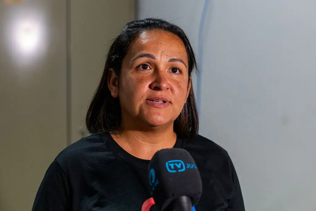 Adeiziely da Silva Tavares, secretária executiva do Posto de Atendimento ao Cidadão, concede entrevista à TV.Jus. ela é uma mulher parda, olhos castanhos, cabelos lisos, chanel e pretos, usando camiseta preta.