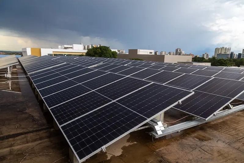 Foto em plano aberto que mostra diversas placas solares instaladas sobre o teto do Tribunal de Justiça