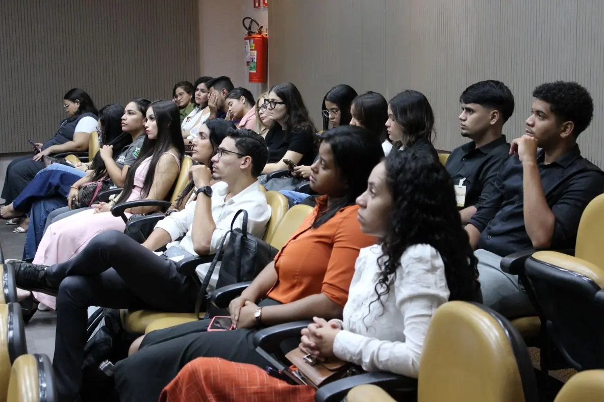 Foto horizontal colorida que mostra dezenas de estudantes de Direito sentados na plateia de um plenário do Tribunal de Justiça assistindo à sessão.