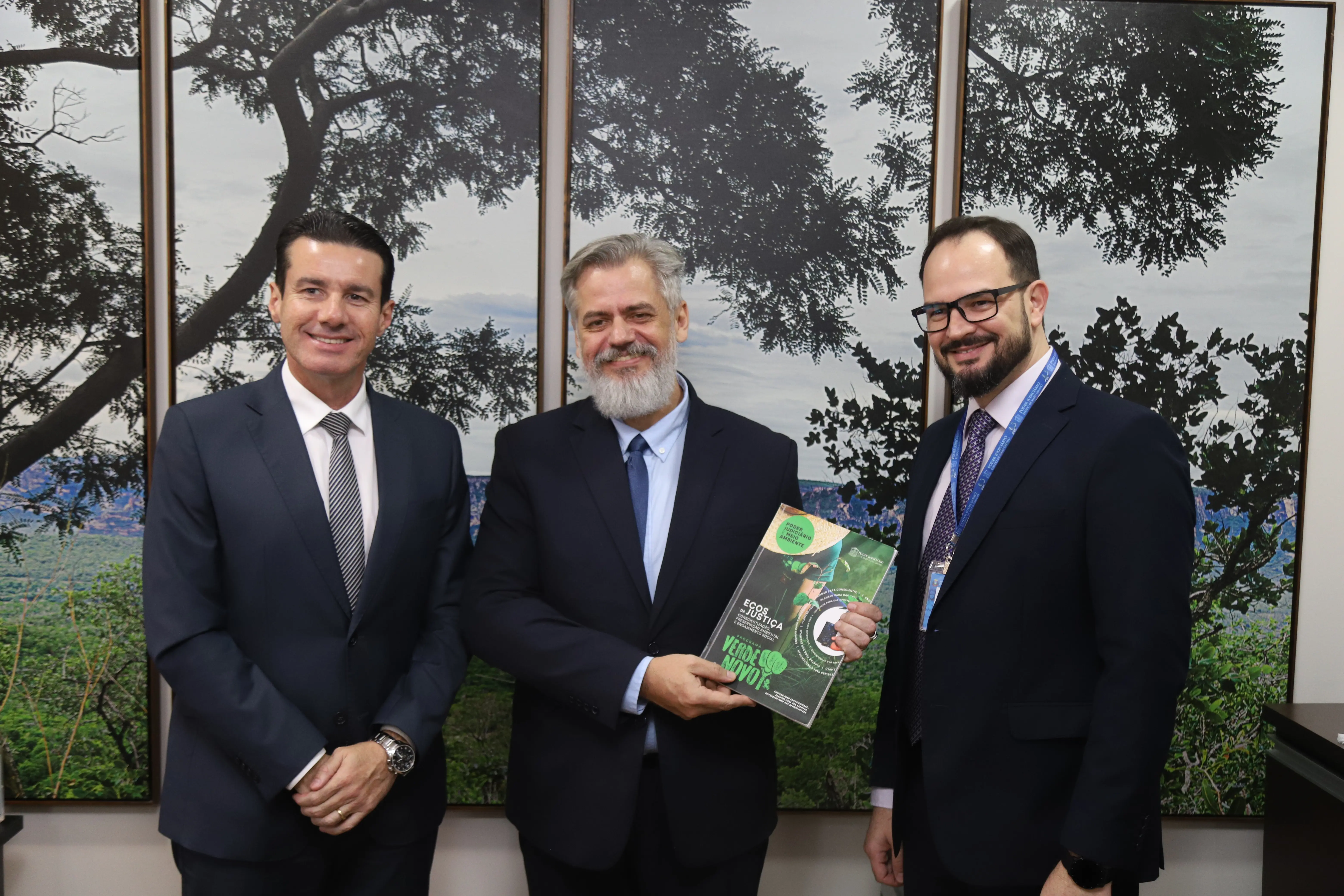 Consultor do Prêmio Innovare, Nivaldo Romko, posa para a foto segurando a revista do programa Verde Novo. Ao lado dele estão o desembargador Rodrigo Curvo e o coordenador do Programa Verde Novo, Sérgio Savioli.