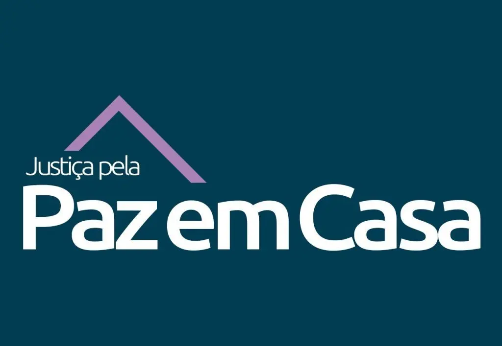 Imagem vertical com fundo azul escuro com o logotipo da Justiça Pela Paz em Casa, campanha do Conselho Nacional de Justiça voltada ao julgamento de casos de violência doméstica. O logotipo é escrito em fonte branca e, no topo, uma imagem triangular lilás, representando o teto de uma casa.