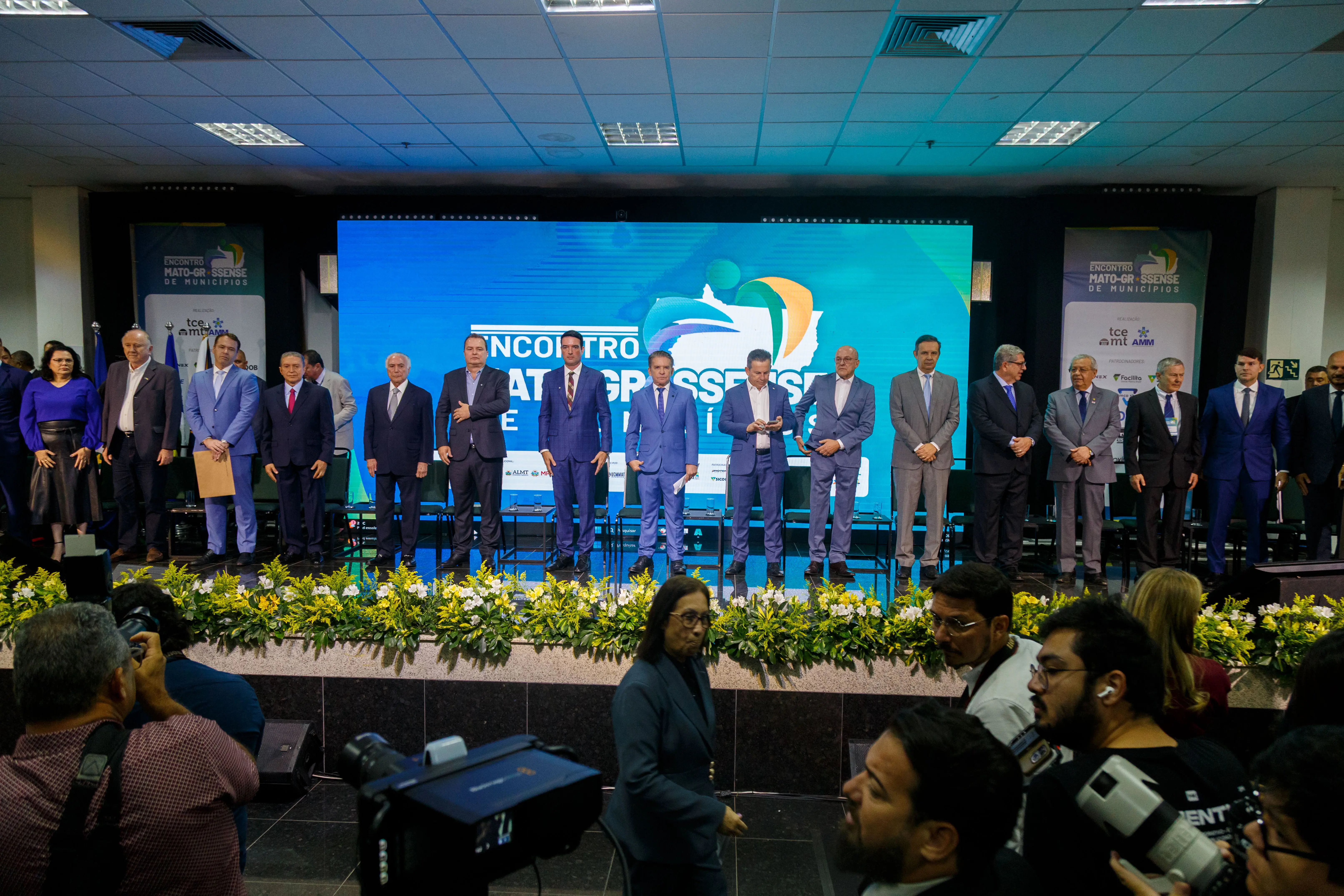Foto horizontal colorida. O juiz Agamenon Moreno está sentado no dispositivo de autoridades. O magistrado está em pé. usa terno cinza e camisa branca. É um homem alto e magro.