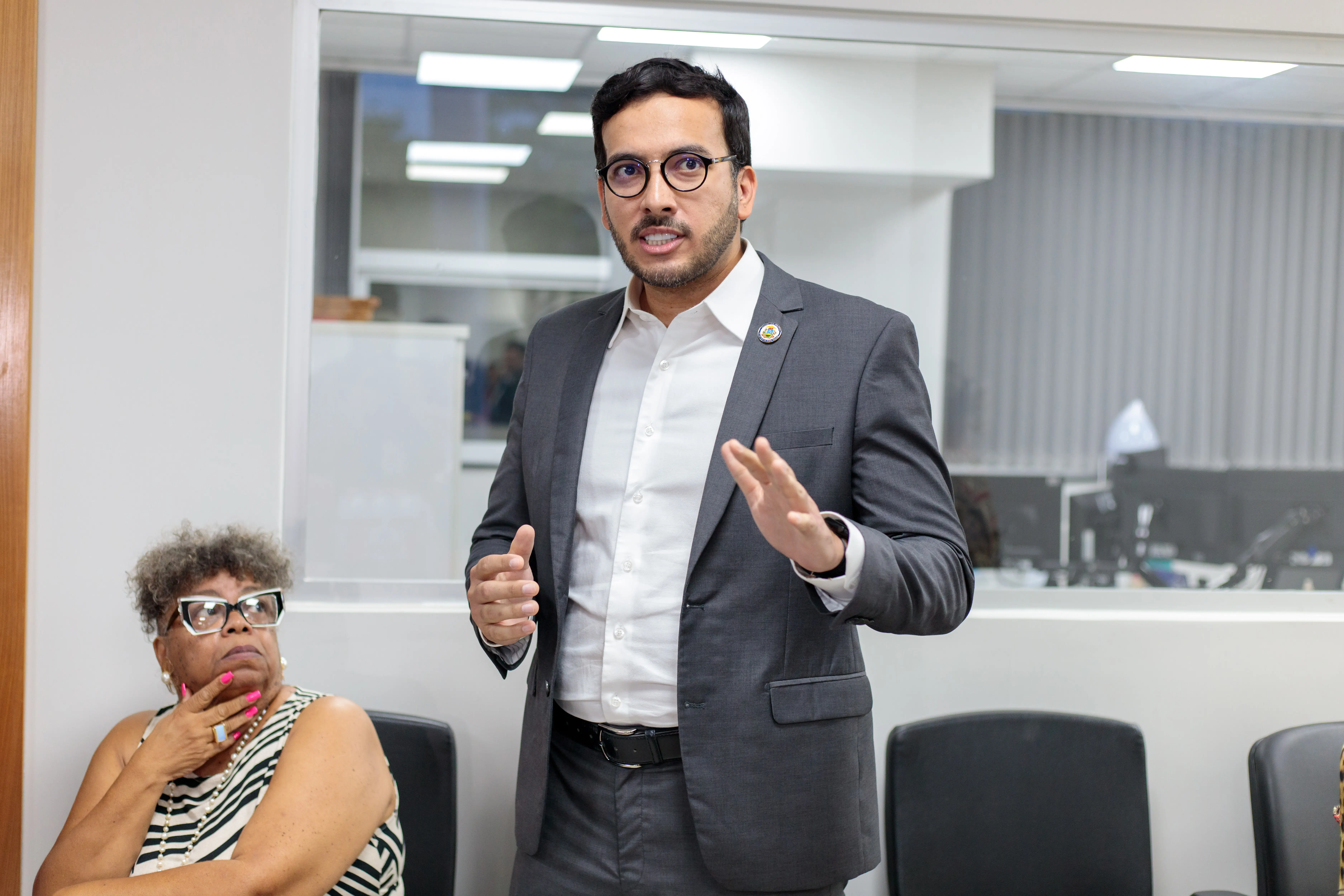 Pedro Calazans, da Maçonaria, que contribui com doações apra casa de amparo, concede entrevista. Ele é um homem branco, com barba cerrada, usa óculos com armação escura, blaser cinza e camisa branca