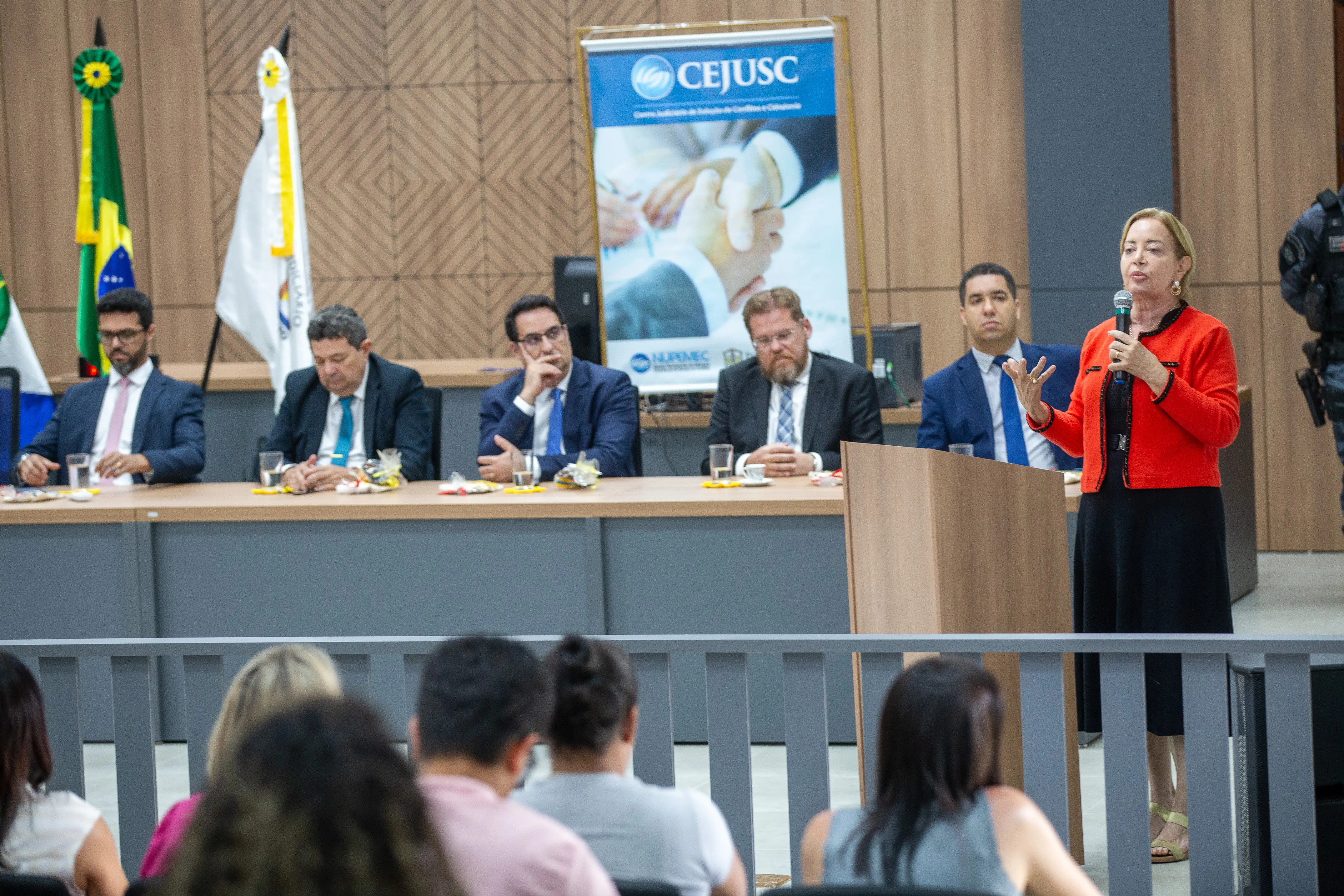foto colorida, na horizontal, da presidente do TJMT durante o discurso no auditório do Fórum de Campo novo do Parecis, ao lado da mesa composta por autoridades locais e do judiciário mato-grossense.