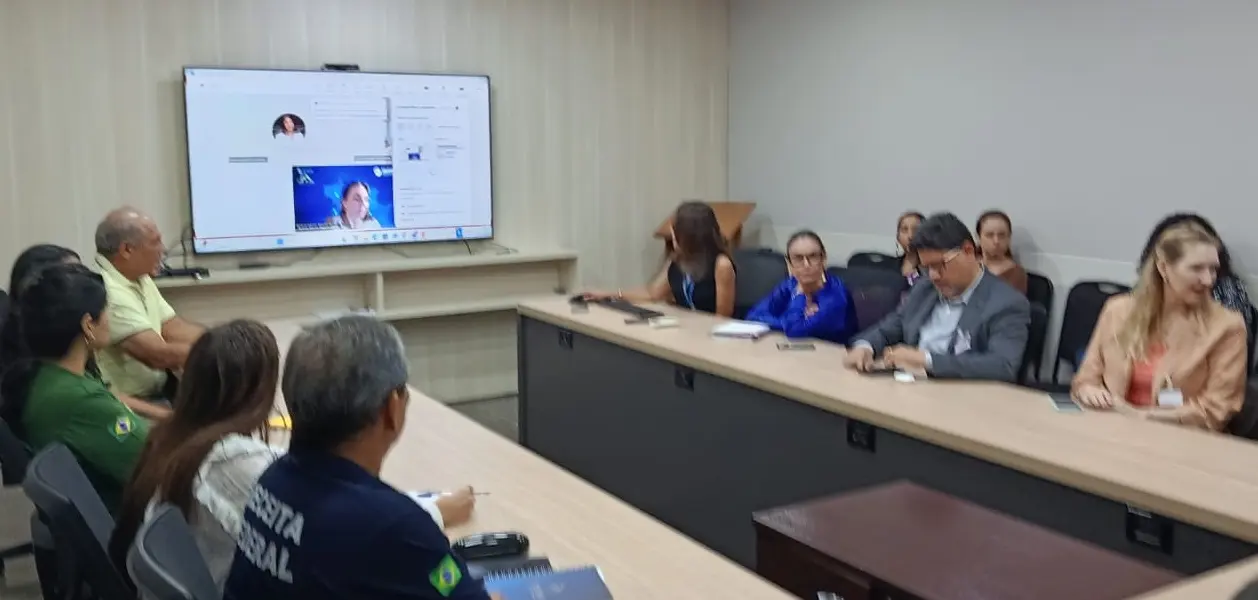 Reunião presencial com representantes de instituições parceiras, sentados ao redor de uma mesa em formato de “U”, em sala de reuniões da Corregedoria, durante alinhamento do Programa Registre-se.