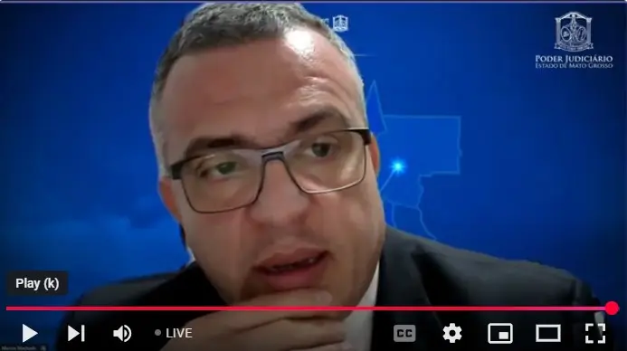 print de tela do desembargador Marcos Machado. Ele é um homem branco, de cabelos grisalhos, que usa óculos de grau