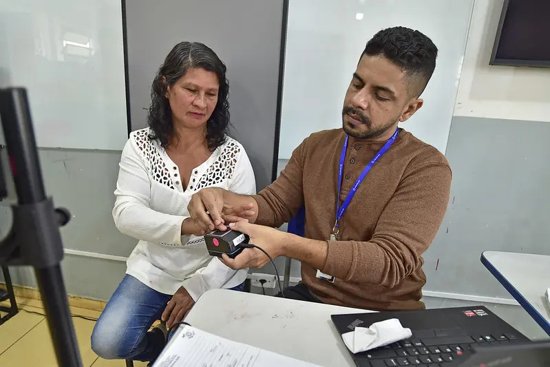 Servidor da Politec colhe biometria de uma mulher.