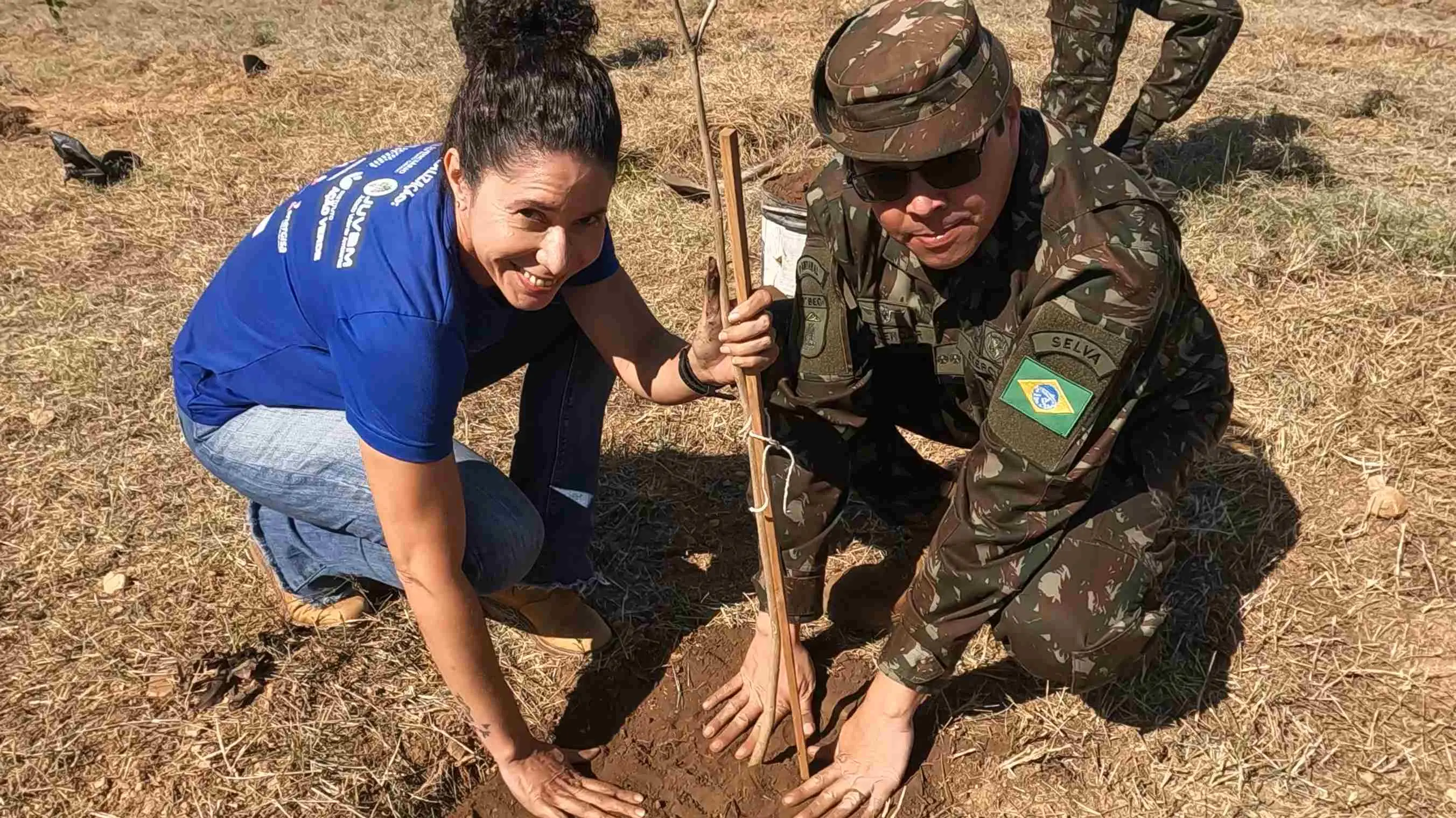 Engenheira do Programa Verde Novo, Rosiane Carvalho, e comandante do 9ºBEC plantam uma muda de árvore.