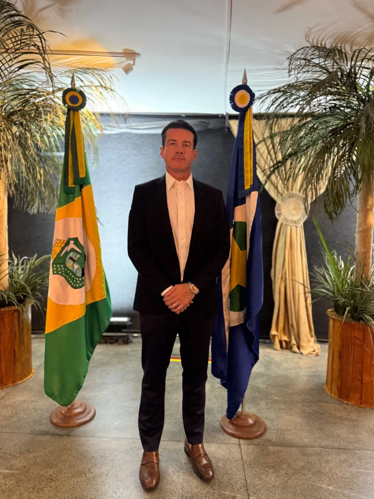 Ouvidor-geral do Poder Judiciário de Mato Grosso, desembargador Rodrigo Curvo, posa para foto em pé, ao lado da bandeira de Mato Grosso.