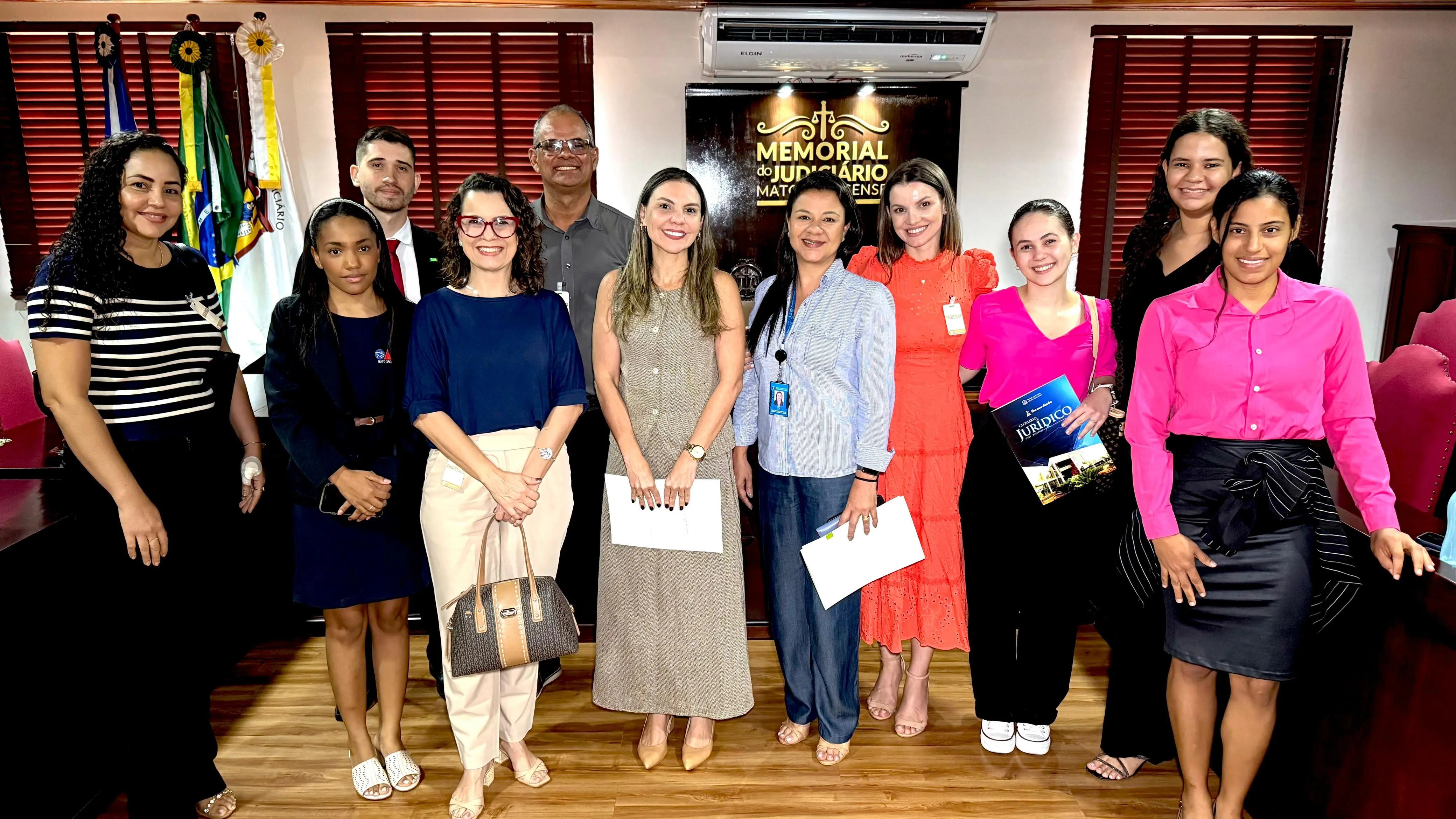Juíza Henriqueta Chaves, professores e alunos da Unifacc posam sorrindo para a foto, no Memorial do Judiciário.