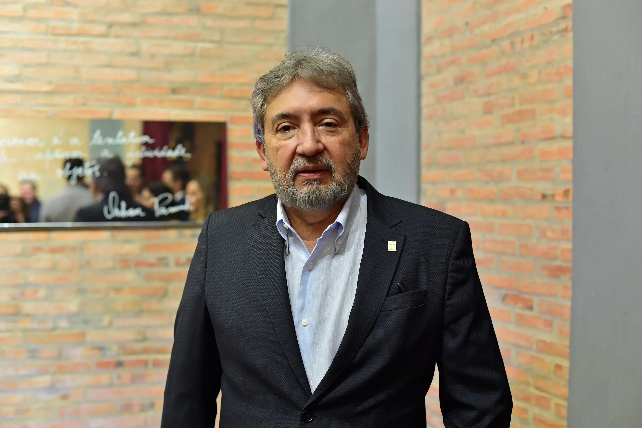 Foto colorida e horizontal. Des. Márcio Vidal, veste paletó preto e camisa azul clara. Ele tem cabelos grisalhos e curtos. Usa barba e bigode